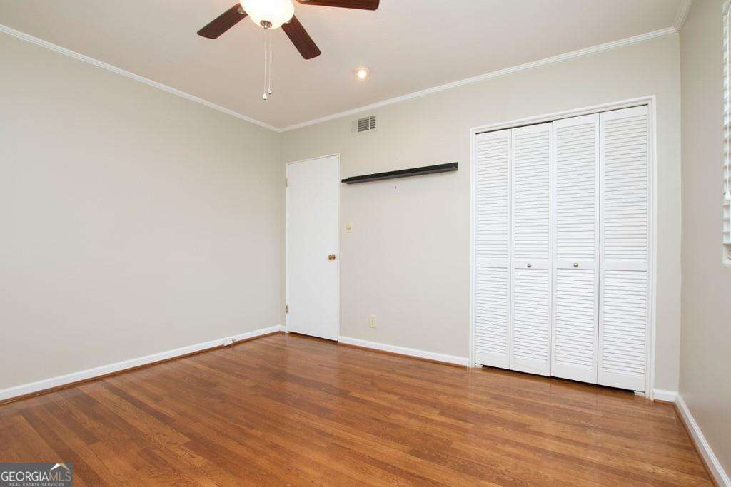3660 Peachtree Road Northeast, Unit E7 Atlanta, GA 30319 - Photo 10 of 17 an empty room with wooden floor ceiling fan and window