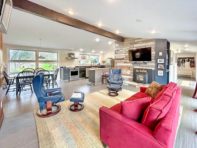 a living room with furniture a flat screen tv and a large window