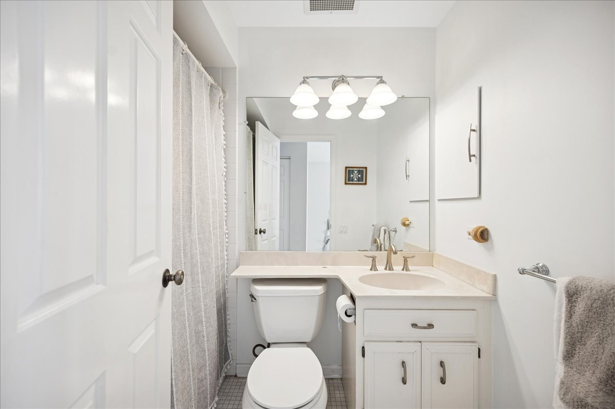 3741 Mission Hills Road, Unit 209 Northbrook, IL 60062 - Photo 16 of 18 a bathroom with a sink a mirror and a toilet