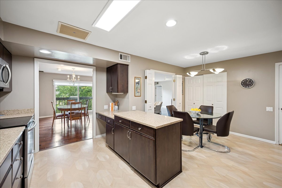 3741 Mission Hills Road, Unit 209 Northbrook, IL 60062 - Photo 7 of 18 a dining hall with stainless steel appliances granite countertop a sink dishwasher a dining table and chairs with wooden floor