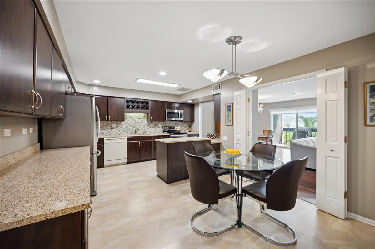 3741 Mission Hills Road, Unit 209 Northbrook, IL 60062 - Photo 8 of 18 a kitchen with stainless steel appliances kitchen island granite countertop a sink a stove a refrigerator cabinets and chairs