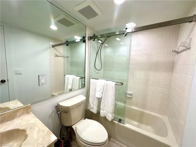 a bathroom with a granite countertop toilet sink and shower