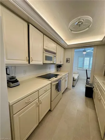 a kitchen with white cabinets and white appliances
