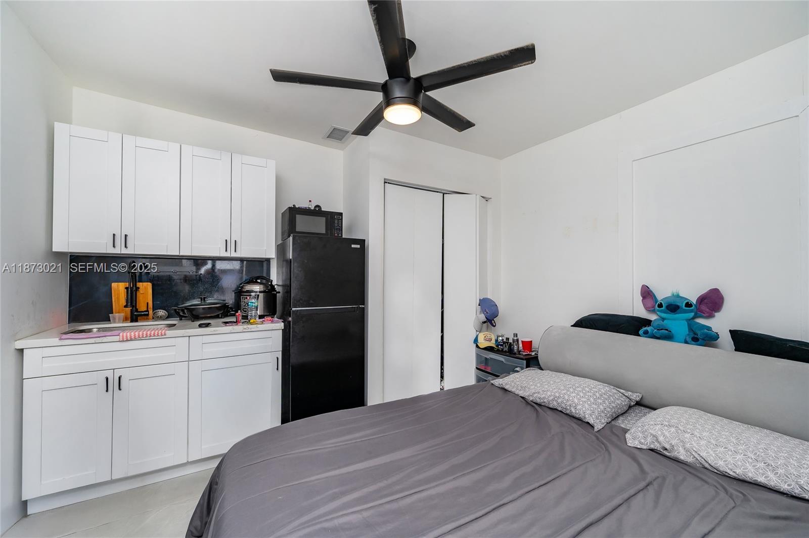 1946 Northwest 49th Street Miami, FL 33142 - Photo 15 of 29 a bedroom with a bed and a refrigerator