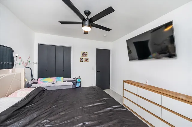 a bedroom with a bed and a flat screen tv
