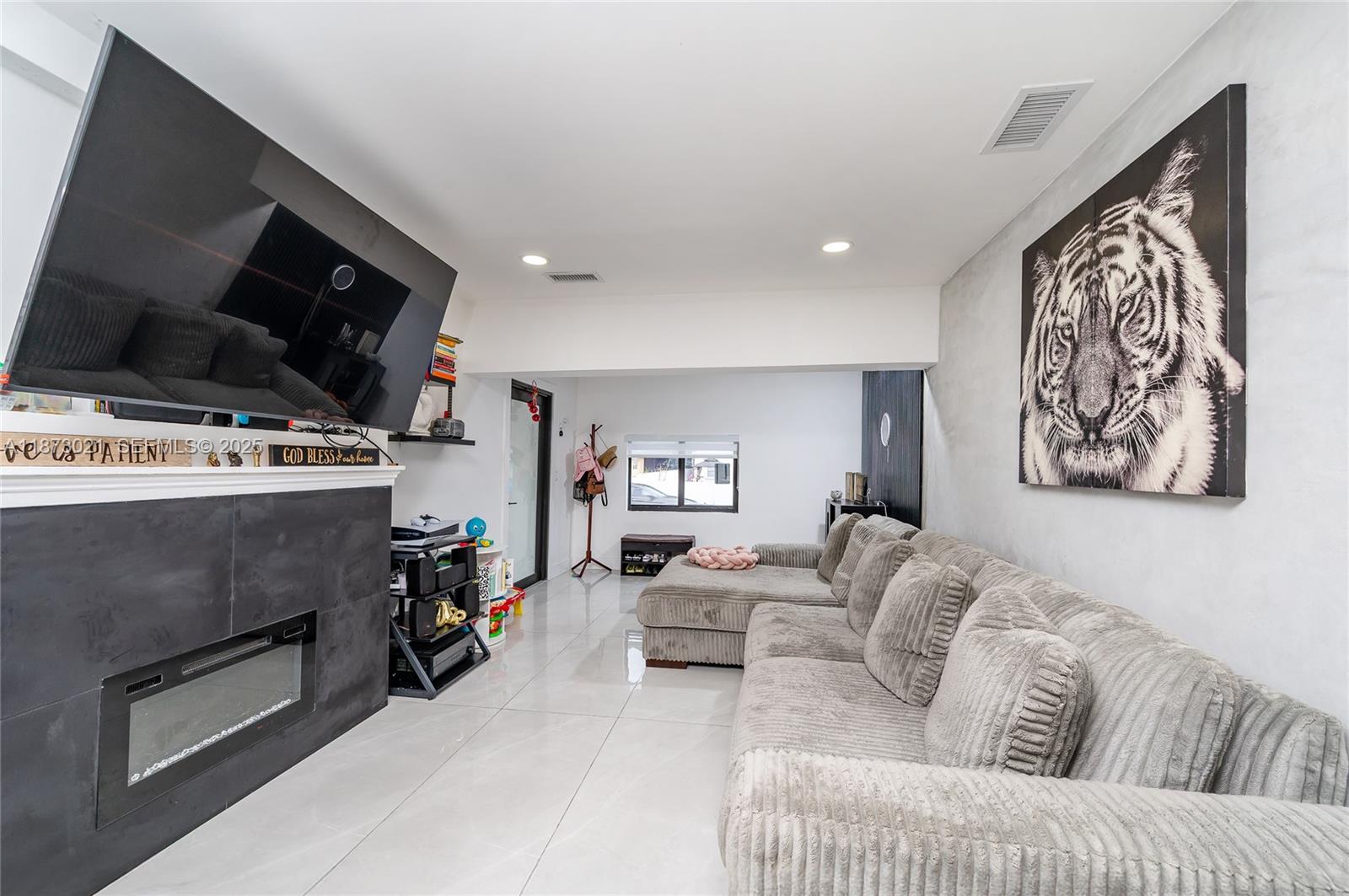 1946 Northwest 49th Street Miami, FL 33142 - Photo 9 of 29 a living room with furniture and a flat screen tv