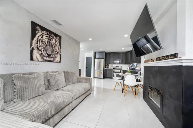 a living room with furniture and kitchen view