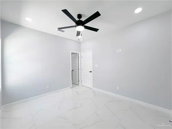 an empty room with a ceiling fan and a window