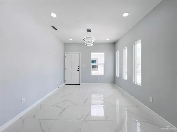 an empty room with windows and cabinet