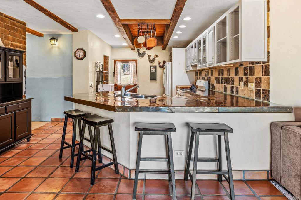 17089 Lawson Valley Road Jamul, CA 91935 - Photo 17 of 33 a dining hall with stainless steel appliances a dining table and chairs with wooden floor