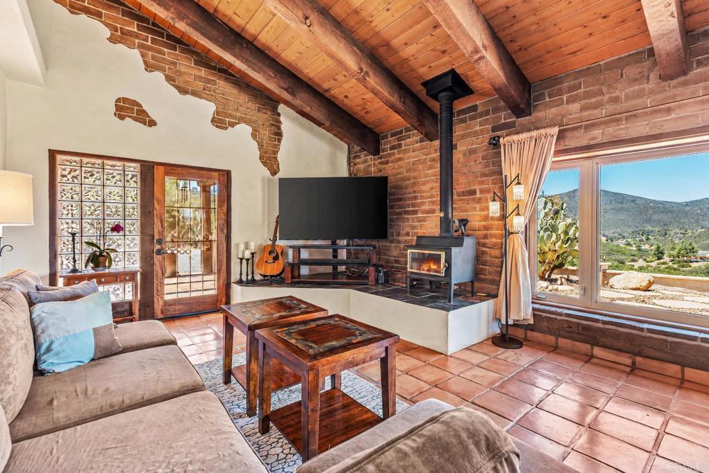 17089 Lawson Valley Road Jamul, CA 91935 - Photo 6 of 33 a living room with furniture a flat screen tv and a floor to ceiling window