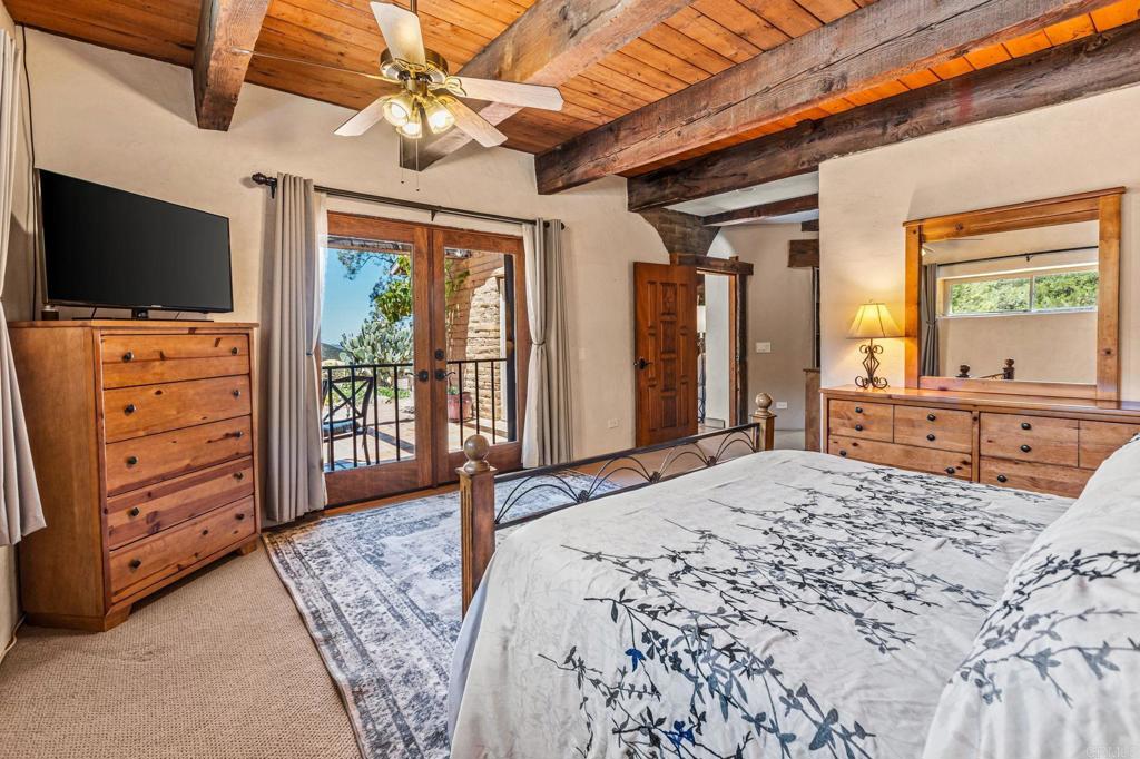 17089 Lawson Valley Road Jamul, CA 91935 - Photo 7 of 33 a bedroom with a bed and a flat screen tv