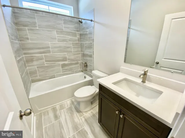 a bathroom with a sink a toilet a mirror and shower