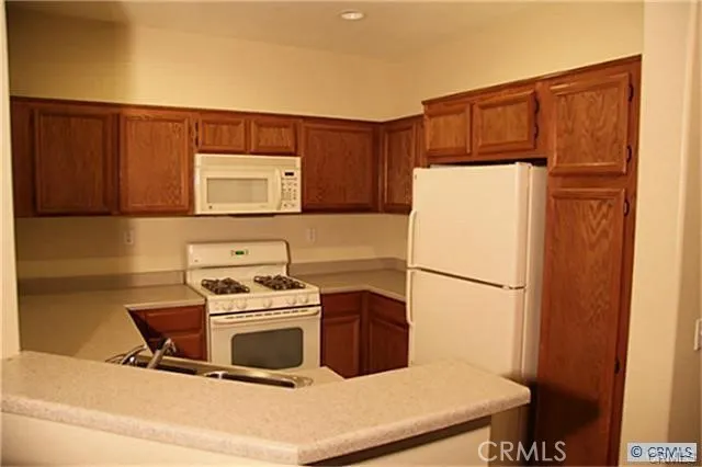 a kitchen with a refrigerator sink stove and cabinets