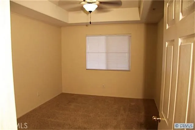 an empty room with a chandelier fan