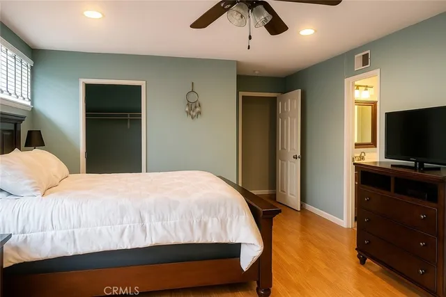 a bedroom with a bed and a flat tv screen on dresser