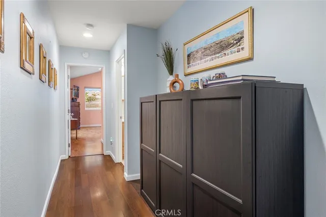 a view of a hallway with wooden floor and staircase