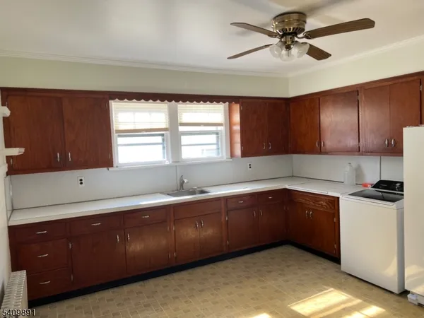 a kitchen with granite countertop a sink cabinets stainless steel appliances and a window