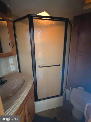 a bathroom with a granite countertop sink toilet and shower