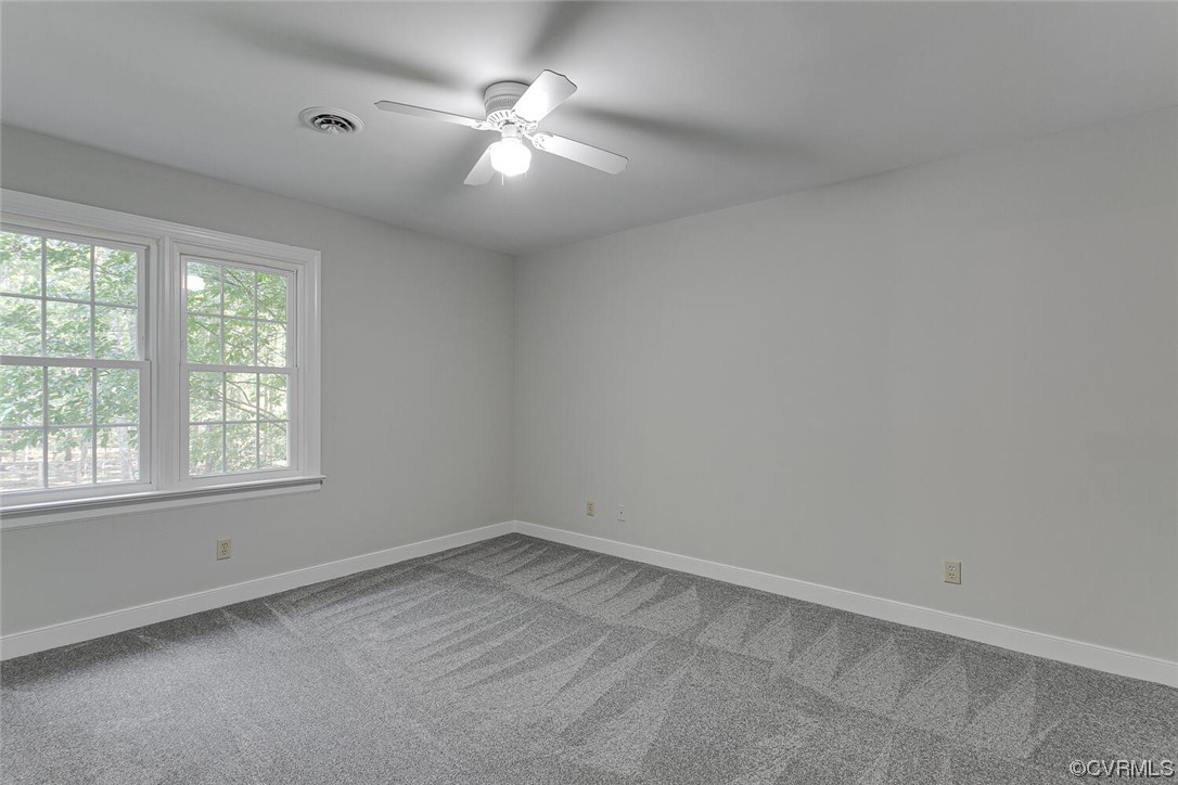 1310 King William Woods Road Midlothian, VA 23113 - Photo 31 of 42 an empty room with a chandelier fan and windows