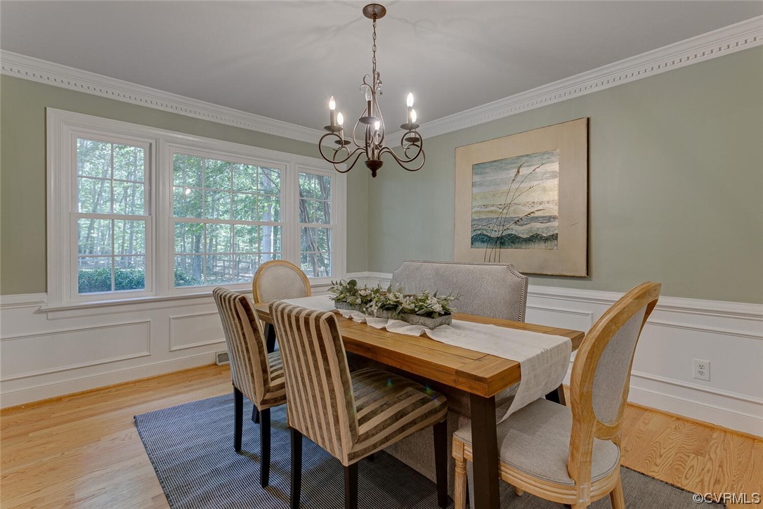 1310 King William Woods Road Midlothian, VA 23113 - Photo 8 of 42 a dining room with furniture a chandelier and wooden floor