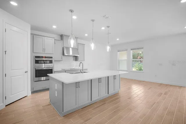 a kitchen with kitchen island a sink stainless steel appliances and cabinets