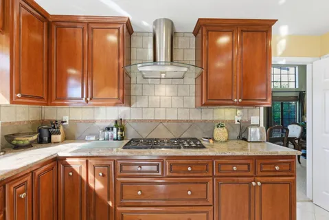 a kitchen with stainless steel appliances granite countertop a sink stove and cabinets