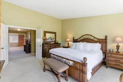 a bedroom with a bed a mirror and dresser