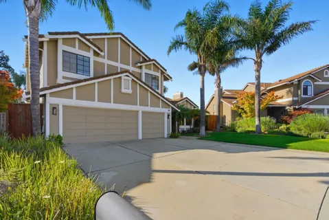 front view of house with a yard and potted plants