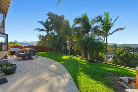 a view of a backyard with a patio table and chairs