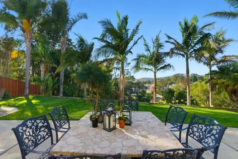 a view of a backyard with a patio table and chairs