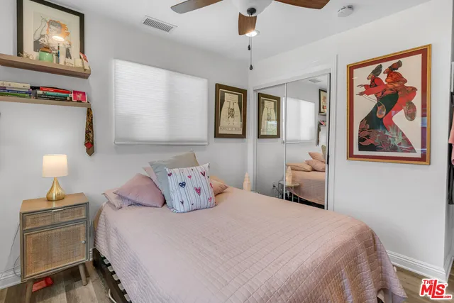 a bedroom with a bed and a lamp on dresser