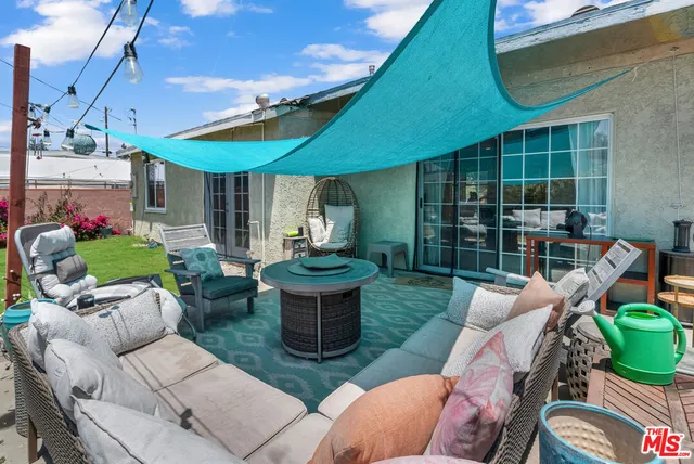 a view of a patio with couches table and chairs and potted plants