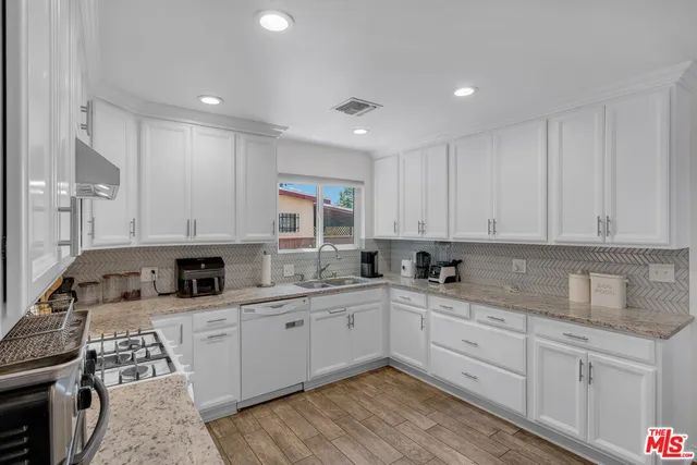 a kitchen with stainless steel appliances granite countertop a sink stove and cabinets