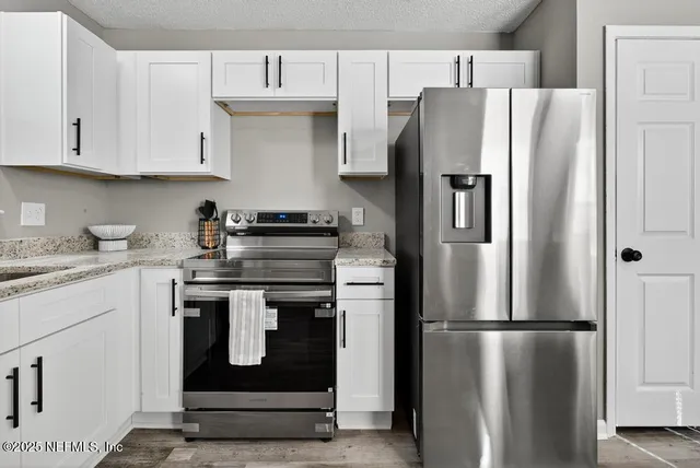 a kitchen with stainless steel appliances granite countertop a refrigerator and a stove