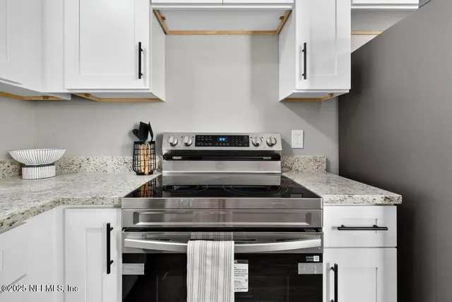 a kitchen with granite countertop a stove a sink and dishwasher