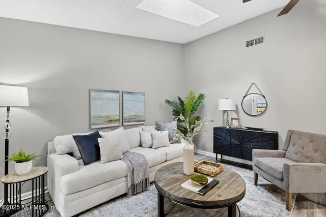 a living room with furniture potted plant and wooden floor