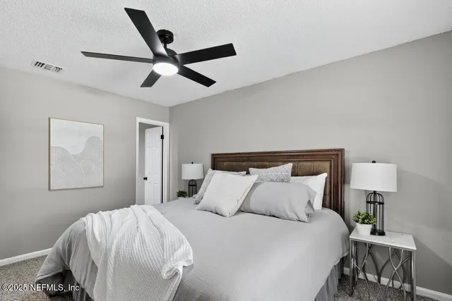 a bedroom with a bed and painting on the wall