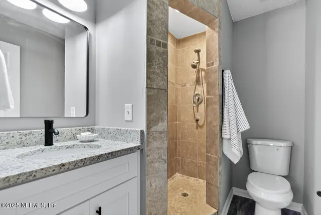 a bathroom with a granite countertop sink toilet and shower