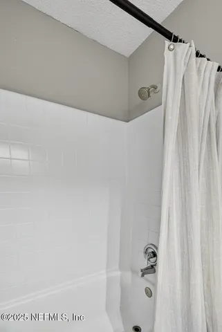 a bathroom with a shower and a tub