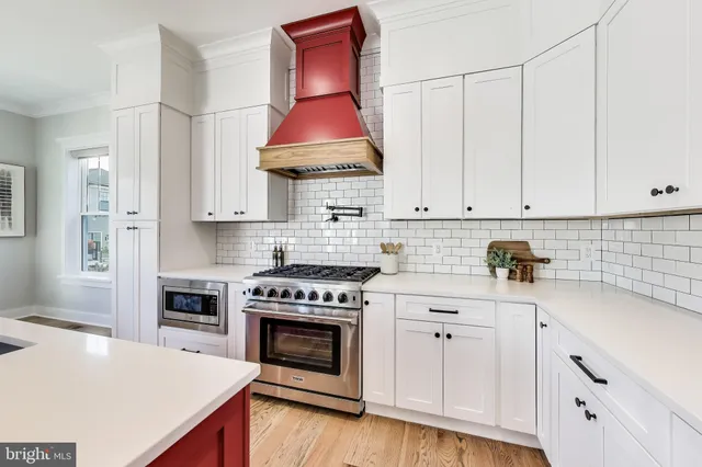 a kitchen with stainless steel appliances granite countertop a sink a stove and a refrigerator