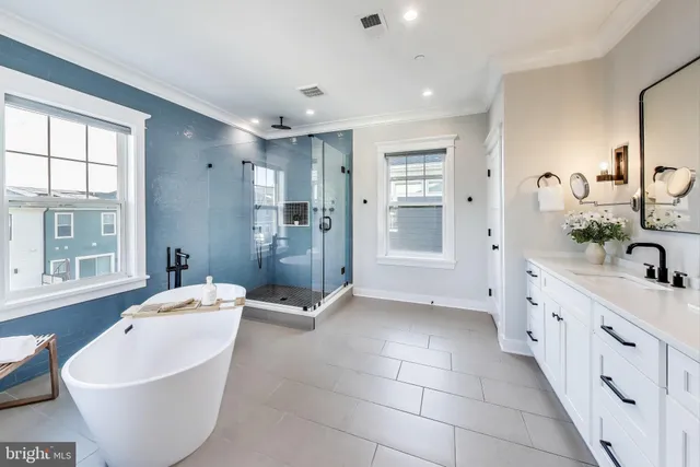 a spacious en suite bathroom with double sink and a mirror