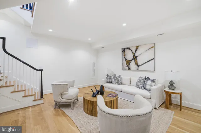 a living room with furniture and a painting on the wall