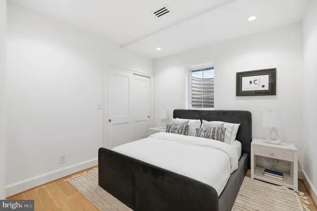 a bedroom with a bed and a painting on the wall