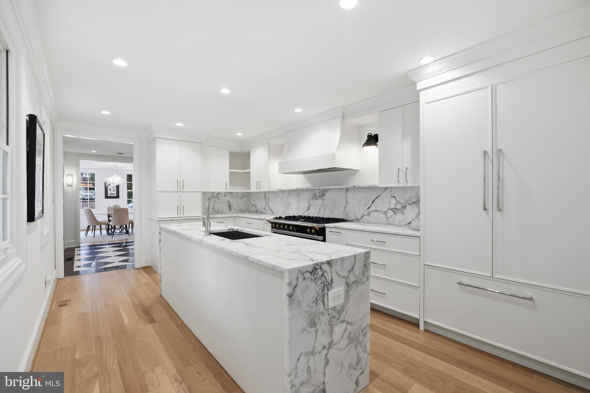 3418 Reservoir Road Northwest Washington, DC 20007 - Photo 5 of 33 a kitchen with a sink a stove a refrigerator and white cabinets with wooden floor