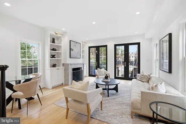 a living room with fireplace furniture and a large window