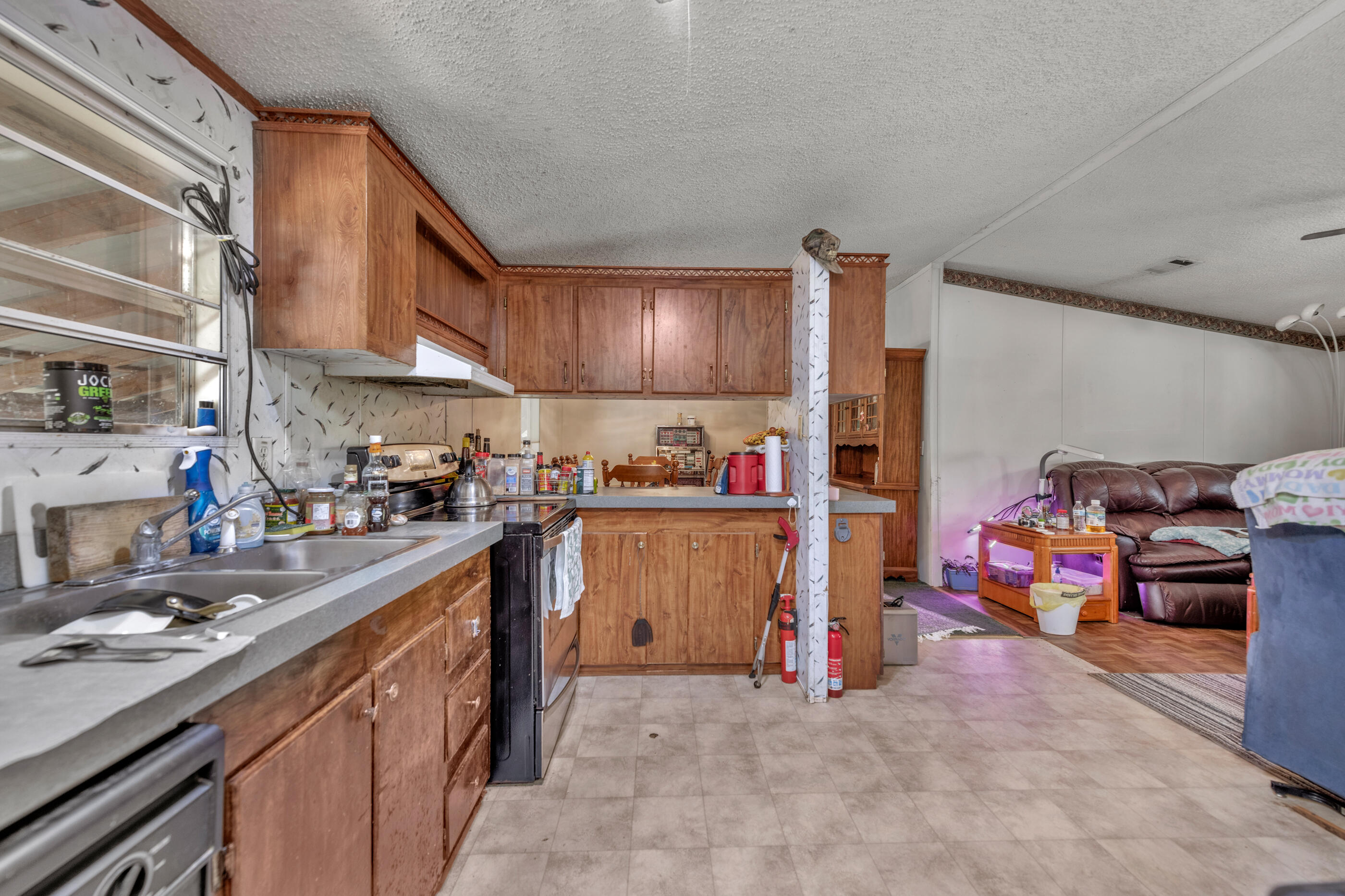 7189 Sherman Kennedy Road Baker, FL 32531 - Photo 10 of 29 a kitchen with lots of clutter and stainless steel appliances