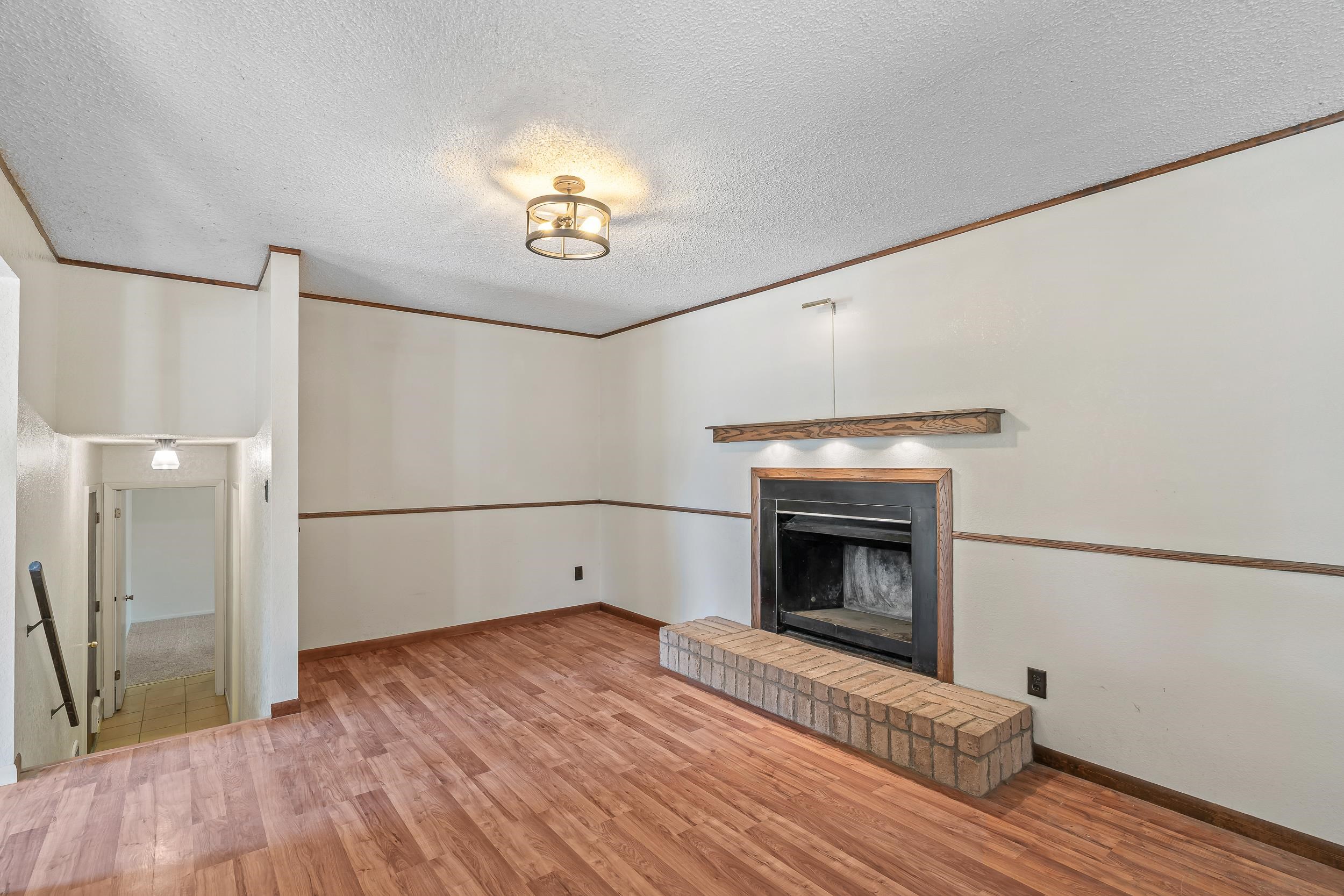 623 Broken Spoke Road Grand Junction, CO 81504 - Photo 11 of 27 a view of an empty room with wooden floor fireplace and a window