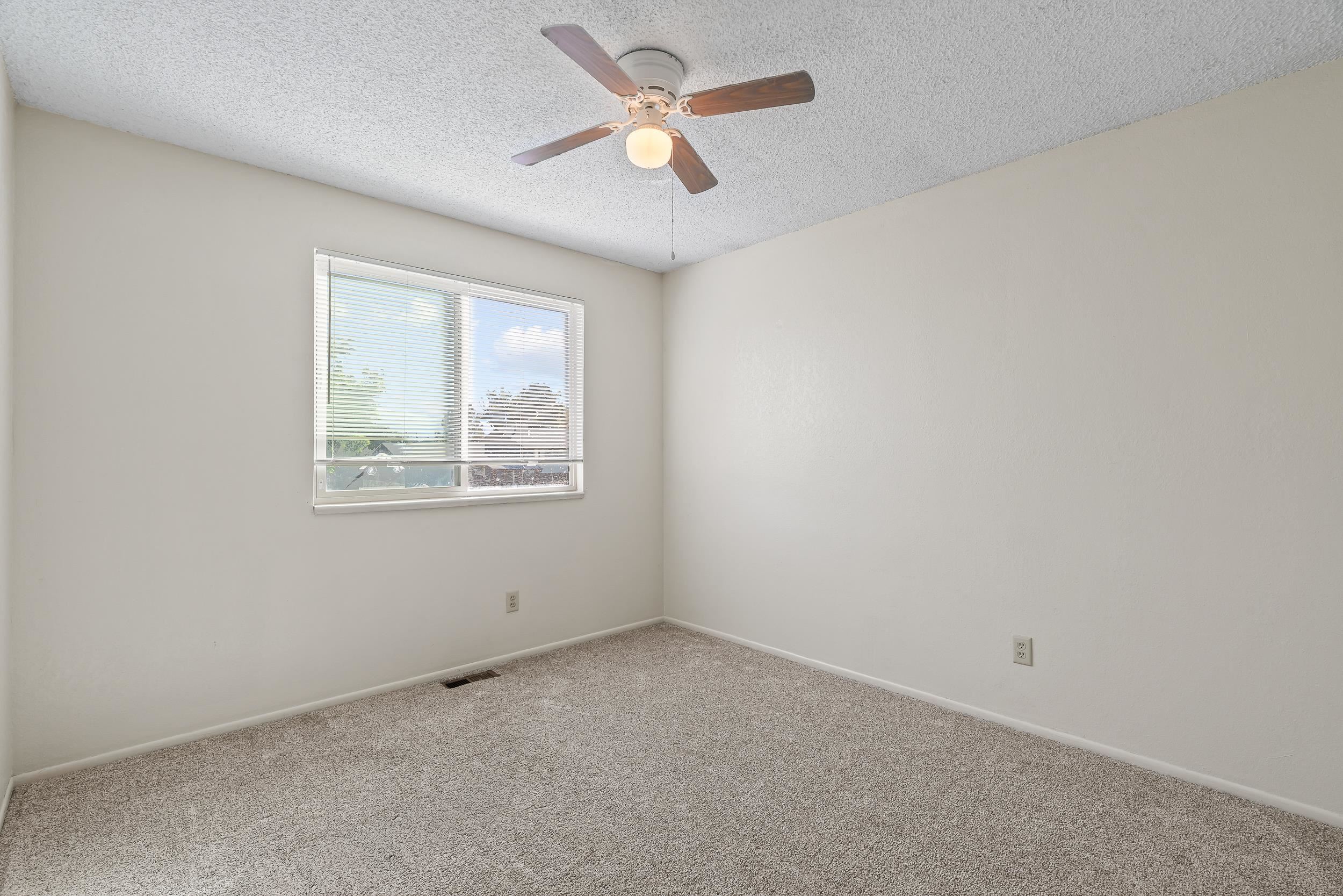 623 Broken Spoke Road Grand Junction, CO 81504 - Photo 18 of 27 an empty room with a window and a ceiling fan