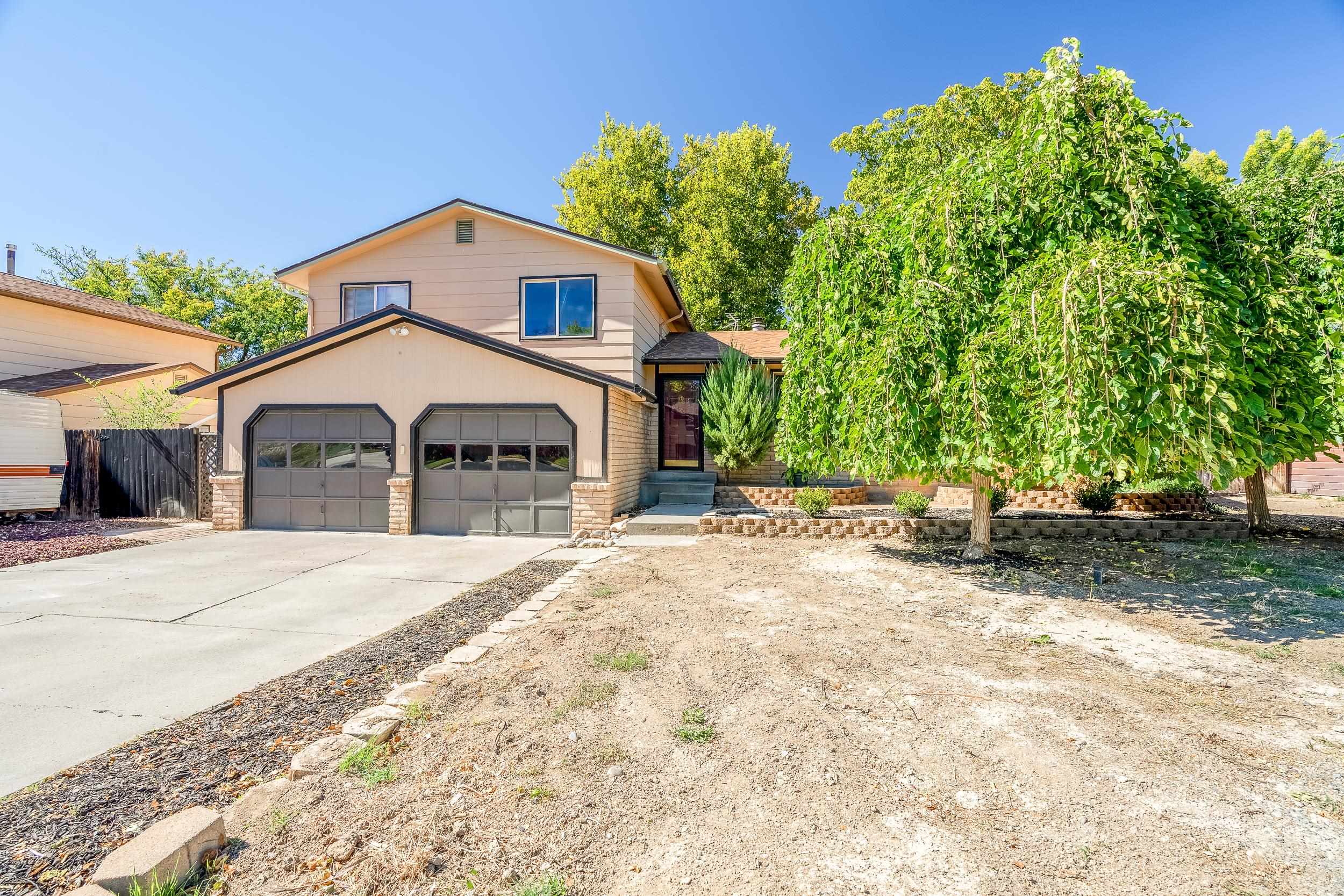 623 Broken Spoke Road Grand Junction, CO 81504 - Photo 27 of 27 a front view of a house with a yard and garage